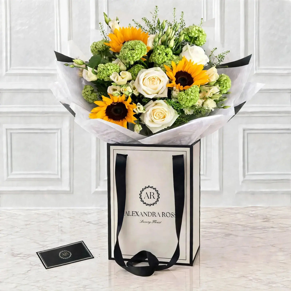 Sunny sunflower bouquet with white roses and green hydrangea in luxury gift bag