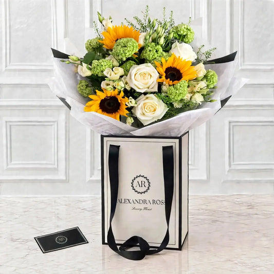 Sunny sunflower bouquet with white roses and green hydrangea in luxury gift bag