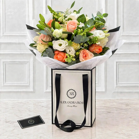 Peach and white Avalanche roses with snapdragons, lisianthus and eucalyptus — a soft, romantic hand-tied bouquet. UK nationwide delivery from £4.95.