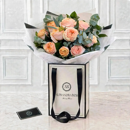 Ecuadorian garden pink roses with fresh eucalyptus, in a soft romantic hand-tied bouquet. Choose half dozen to two dozen, delivered UK-wide.