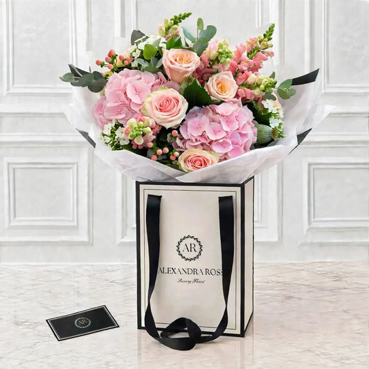 A delicate pastel bouquet of hydrangea, peach Avalanche roses, snapdragons and eucalyptus, handmade in Rochdale. Nationwide UK delivery available.